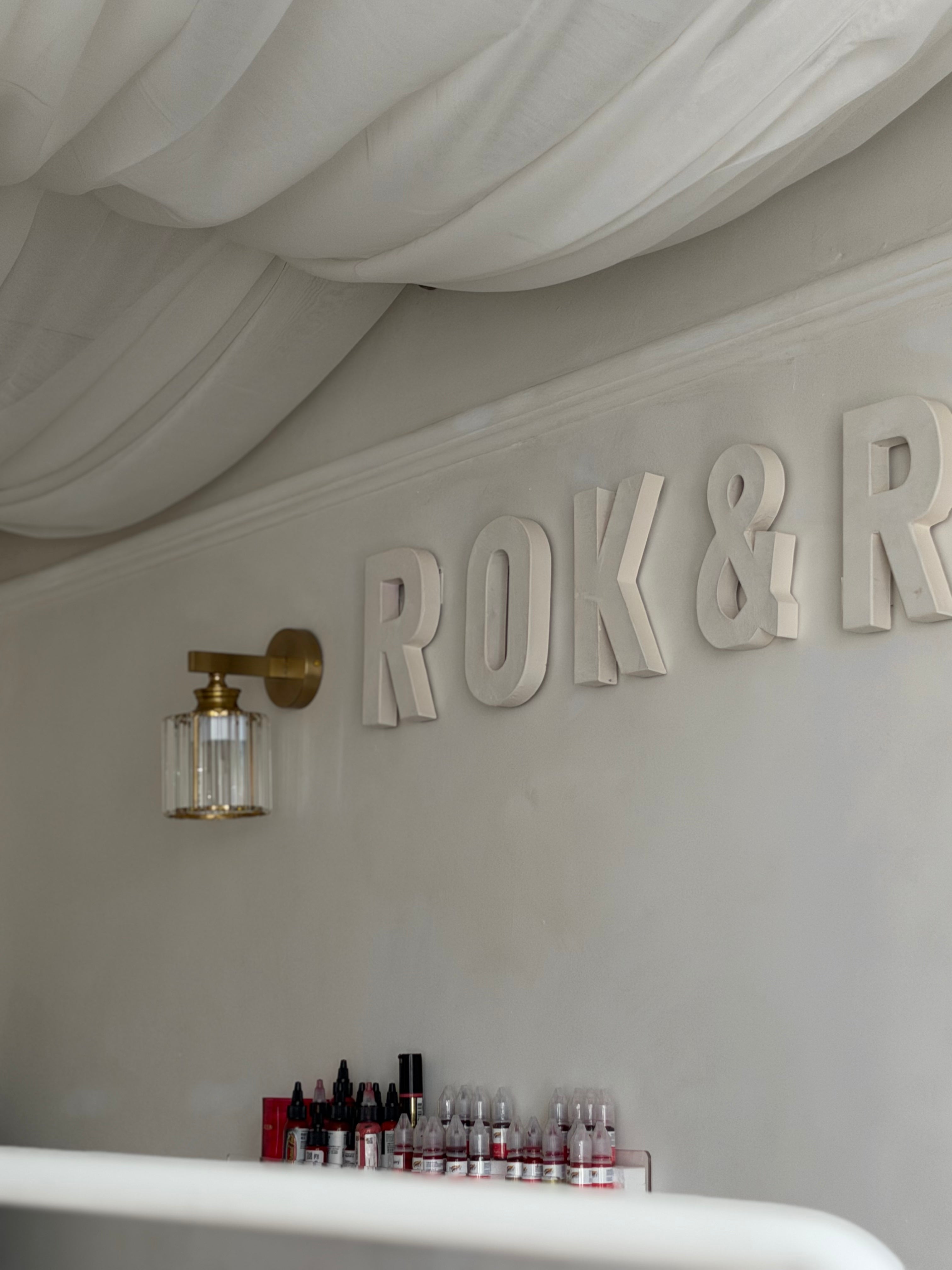Decorative wall with 'ROK & R' letters and a ceiling light fixture.